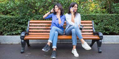 Bir yaz parkta bir cep telefonu konuşurken iki orta yaşlı kadın. Kavram - bir kadının etkin yaş.