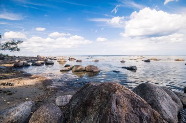 Güneşli yaz gününde Baltık Denizi kıyısında büyük taşlar.