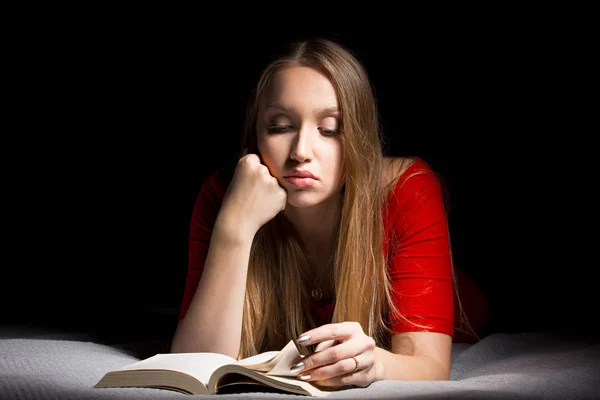 The girl the blonde with long hair reads the book. Concept of intellectual and educational leisure.