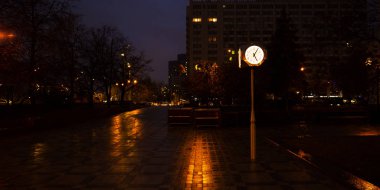 Elektrik direği saat ağaç aydınlatır. Sokak aydınlatma düşük ışıkta fotoğraf.
