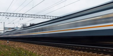 Tren istasyondan ayrılıyor ve demiryolu ile hareket eder. Uzun pozlama fotoğraf.