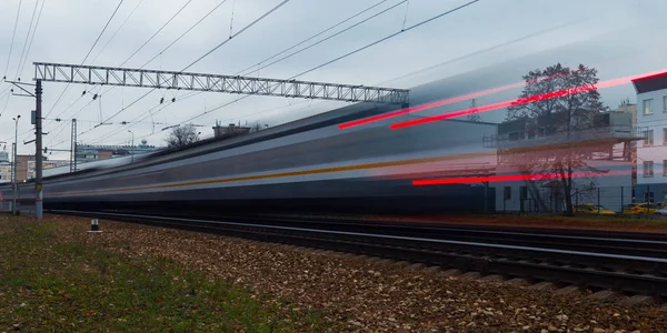 高速列車は 発信の列車に追いつく概念の象徴として駅を通過します 長時間露光で撮影した写真 ぼやけている車 — ストック写真