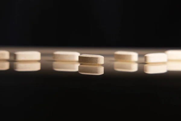 Pills and biologically active additives in the reflection on the desk. Concept of biologically active food supplements.