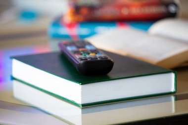 TV eğlence ve haber yayın bir sembolü olarak uzak. Eğlence vs kitap ve eğitim okuma kavramı