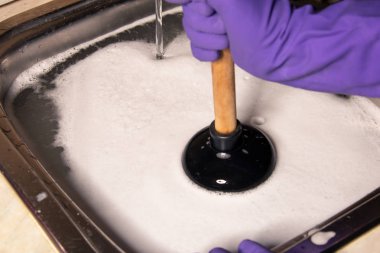 Tıkanmış borular ve mutfak lavaboda. Nasıl bir pistonu ile tıkanıklıkları düzeltmek için kavramı.