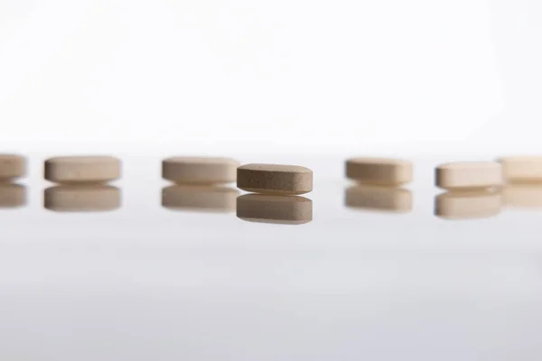 Pills and biologically active additives in the reflection on the desk. Concept of biologically active food supplements.