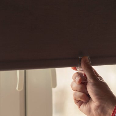 Bir adam perdeleri odasında sıcak tutmak ve Taslaklar önlemek için Windows kapanır.