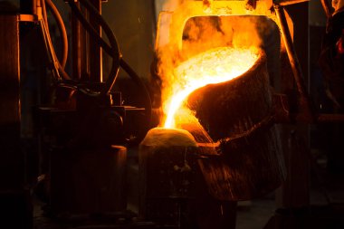 Dökme demir ve çelik için eritme fırını ve fabrika ekipmanları. Erimiş sıvı metal kalıba dökülüyor..