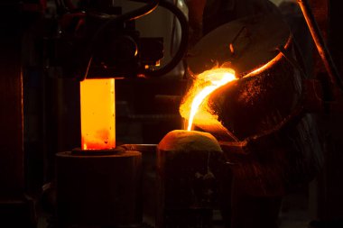 Dökme demir ve çelik için eritme fırını ve fabrika ekipmanları. Erimiş sıvı metal kalıba dökülüyor..