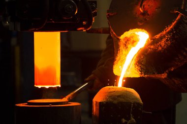 Dökme demir ve çelik için eritme fırını ve fabrika ekipmanları. Erimiş sıvı metal kalıba dökülüyor..