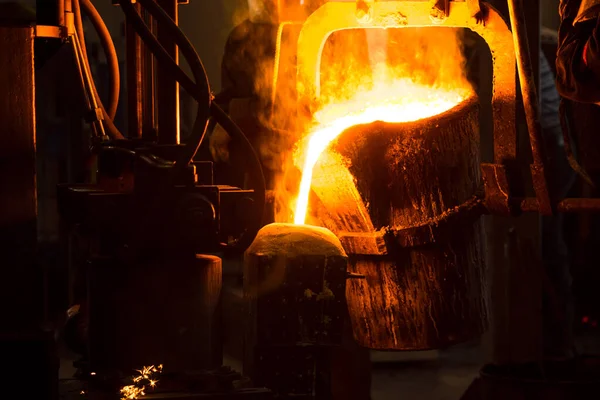 铸钢熔炼炉和工厂设备 熔融的液态金属倒入模子中 免版税图库照片