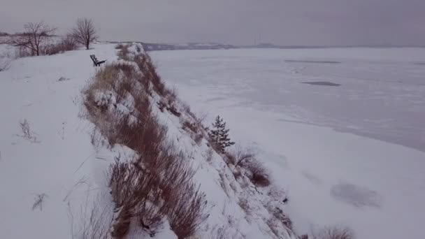 Vídeo aéreo 4k. Paisaje invernal en el pueblo y el río. Luz cálida del atardecer . — Vídeo de stock