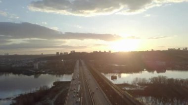 Güneşli sonbahar gününde nehir üzerindeki trafik köprüsünde havadan görünüm, köprüdeki arabalar