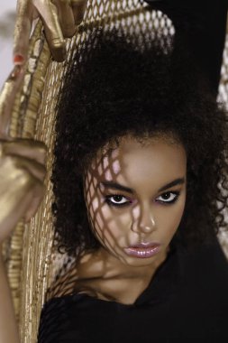 Afro bukleler saç modeli ile siyah pelerin güzel kadın Moda stüdyosu portre. Moda ve güzellik