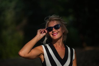 gün batımında sonbahar ormandaki güzel sarışın kadın