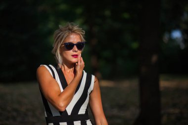 gün batımında sonbahar ormandaki güzel sarışın kadın