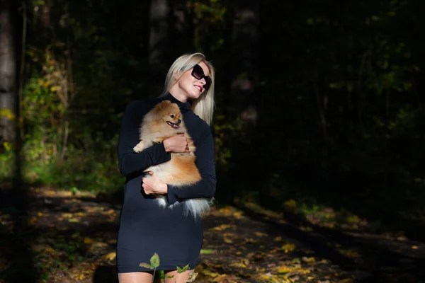 Glad ung modekvinna med dvärgspott i höstskogen — Stockfoto