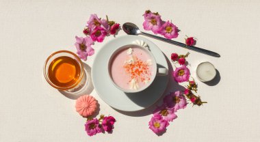 Baharatlı, gül çiçeği, bal ve kremalı pembe ay sütü. Gölgelerle aydınlık. Beyaz arkaplanda boşluk olan üst görünüm
