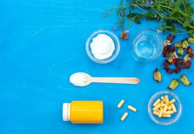 İlaç karışımı, tabletler ve mavi arka plandaki haplar için bir kavanoz hazırlamak için tozlu bir düzen. Boşluğun kopyası