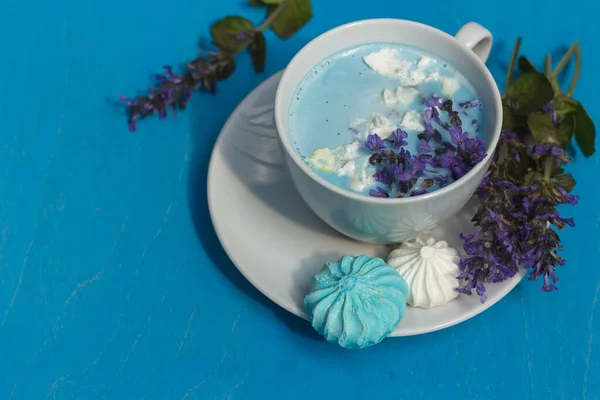 Синій місяць молоко прикрашене блакитними квітами і крихтами на яскраво-блакитному фоні — стокове фото