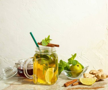 Naneli ve tarçınlı cam bardakta limon ve zencefilli ince bir kokteyl.