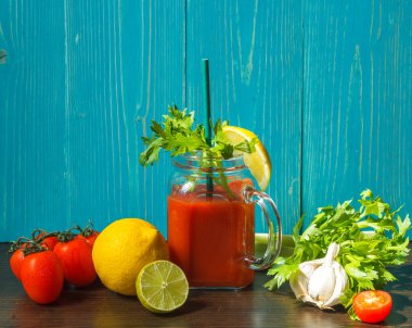 Domates püresi, kereviz, limon ve sarımsak. Kilo kaybı ve vücut zehirlenmesinden arınmak için. Mavi ahşap arka planda yatay bileşim.