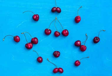 Değişik kirazların mavi arka planında çirkin büyüyen atıklardan, mavi arkaplanda, üst görünümde