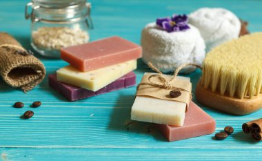 Renkli sabun, havlu ve kuru masaj fırçasıyla kaplıca hayatı. Mavi ahşap bir yüzeyde