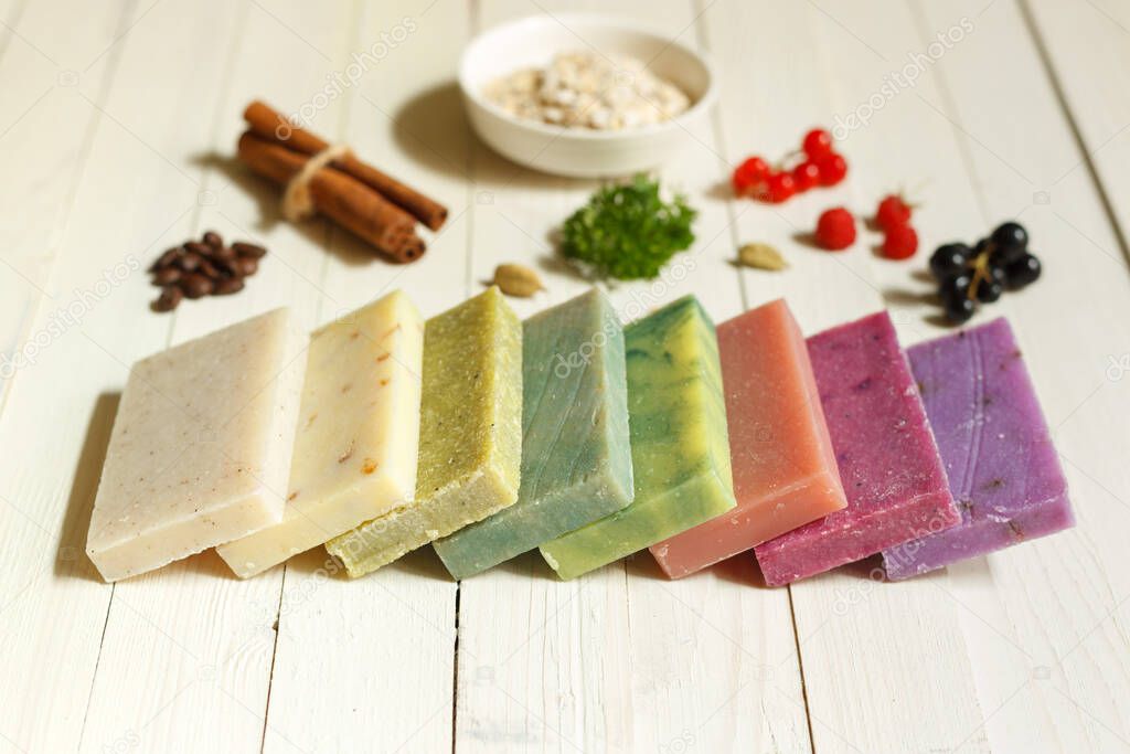 Pieces of colored soap with natural ingredients on a light wooden surface. horizontal orientation