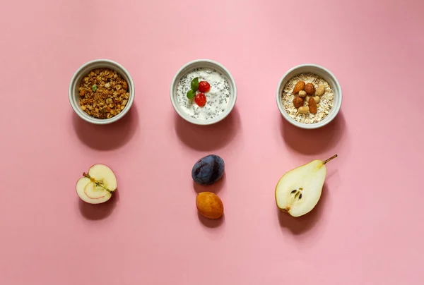 Saludable Desayuno con granola, avena, yogur y fruta. Diseño sobre un fondo rosa horizontalmente — Foto de Stock