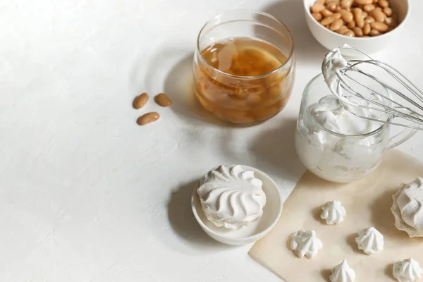 Copa con aquafaba batida, para hacer malvaviscos y merengues. frasco con aquafaba y frijoles blancos, sobre un fondo blanco — Foto de Stock