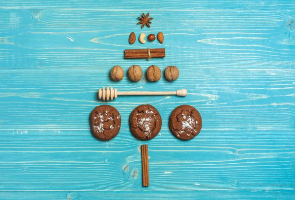 Galletas, nueces y especias dispuestas en forma de árbol de Navidad sobre un fondo azul de madera. Diseño superior con espacio para texto — Foto de Stock