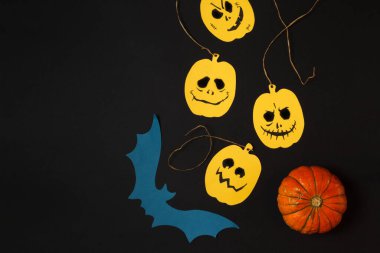 Cadılar Bayramı için içerik. Siyah arka plan, sarı balkabağı ve boyalı yüzler. Boşluğu olan düz alan