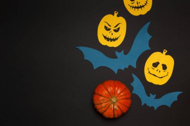 Cadılar Bayramı için kartpostal. Siyah arka plan, sarı balkabağı ve boyalı yüzler. Boşluğu olan düz alan