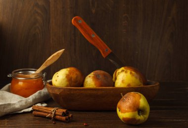 Ahşap bir kasede siyah lekeli çürük elmalar. Koyu ahşap bir masada, yatay olarak uzayla.