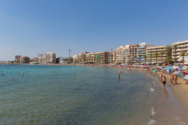 Turistler ve güzel İspanyol Ekim ayında tatilciler ile meşgul bir plaj Playa Cura, Torrevieja, İspanya Cumartesi 6 Ekim 2018 Tarih, gün ışığım