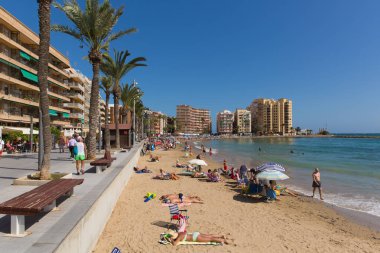 Turistler ve ziyaretçiler Playa Cura plajda, Torrevieja, İspanya Pazar 7 Ekim 2018 üzerinde güzel Ekim İspanyol güneşli havanın tadını