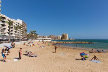Turistler ve ziyaretçiler Playa Cura plajda, Torrevieja, İspanya Pazar 7 Ekim 2018 üzerinde güzel Ekim İspanyol güneşli havanın tadını