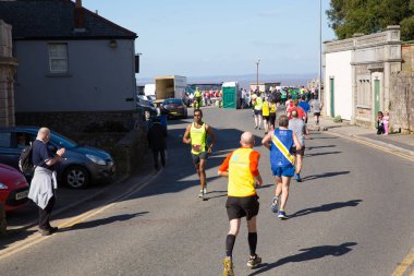 Weston-Super-Mare, Somerset-24 Mart 2019: Weston-super-Mare, Somerset 'te 24 Mart 2019 Weston Super Maratonu sırasında Birnbeck Rd' de koşucular