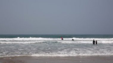 Porthtowan Cornish kuzey kıyısında sörf tahtaları ile wetsuits dalgalar ve denizde eğlenmek insanlar ile Cornwall