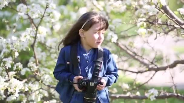 Uma Menina Bonita Está Segurando Uma Câmera Foto Suas Mãos — Vídeo de Stock