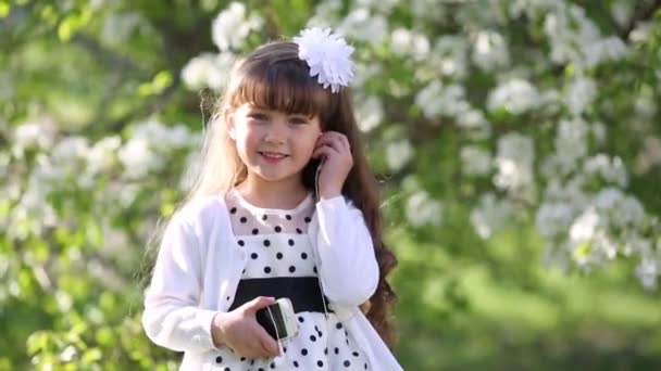 Uma Menina Vestido Branco Ouve Música Através Pequenos Auscultadores Áudio — Vídeo de Stock