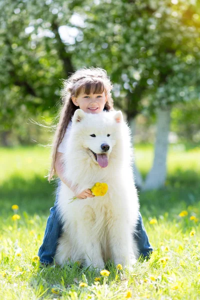 Güzel bir 5 yıl eski kız Jeans favori köpeğini yaz yürüyüş sırasında hugs..