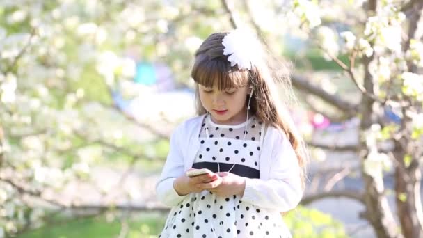 Una Niña Vestido Blanco Escucha Música Través Pequeños Auriculares Audio — Vídeos de Stock