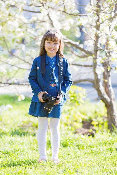 소녀는 그녀의 카메라를 소녀는 과수원에서 사진을 걸립니다 — 스톡 사진