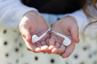 El avuç içi cep telefonuyla kulaklıklar vardır.