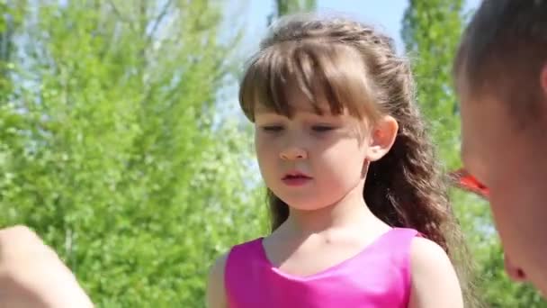 Petite fille joue avec des bulles de savon.Les parents laissent les bulles de savon sur leur fille en été dans le parc .