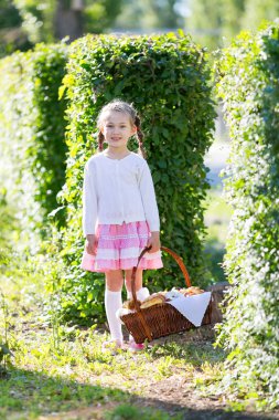 Kız bir sepet ekmek dolu tutan, rulo ve ürünler un. Ekmek sepeti ile küçük kız.