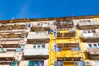 İşçiler ve sıcak cephe bina onarım. Eski ev mineral yün ile sıkıştırılır ve binanın dış kaplı. Sigortası olmayan yükseklikte çalışma