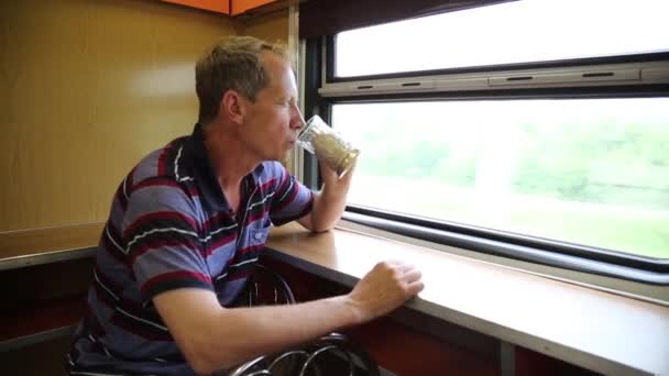 鉄道レストランで男が乗っています 歳の男は 長距離列車でお茶を飲んでいます — ストック動画